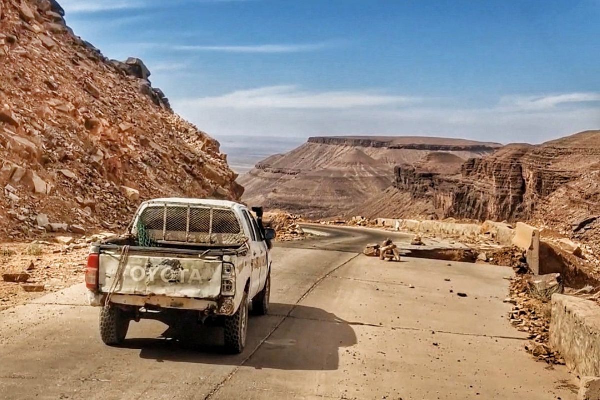 Jeep fährt in der wüste Mauretaniens eine steile Straße